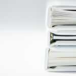 A Stack of Thick Folders on a White Surface