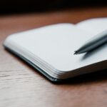 Gray Ballpoint Pen on Top of White Book